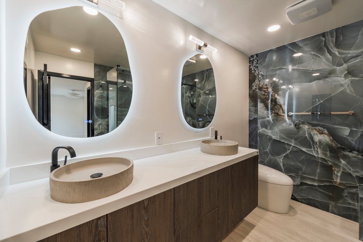 Dual vanity bathroom with vessel sinks, matte black hardware, and ambient lighting