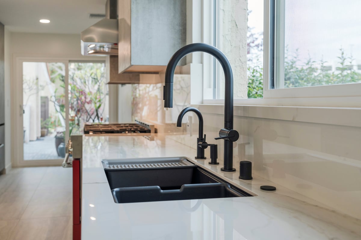 Porcelain countertops with a workstation sink with black hardware