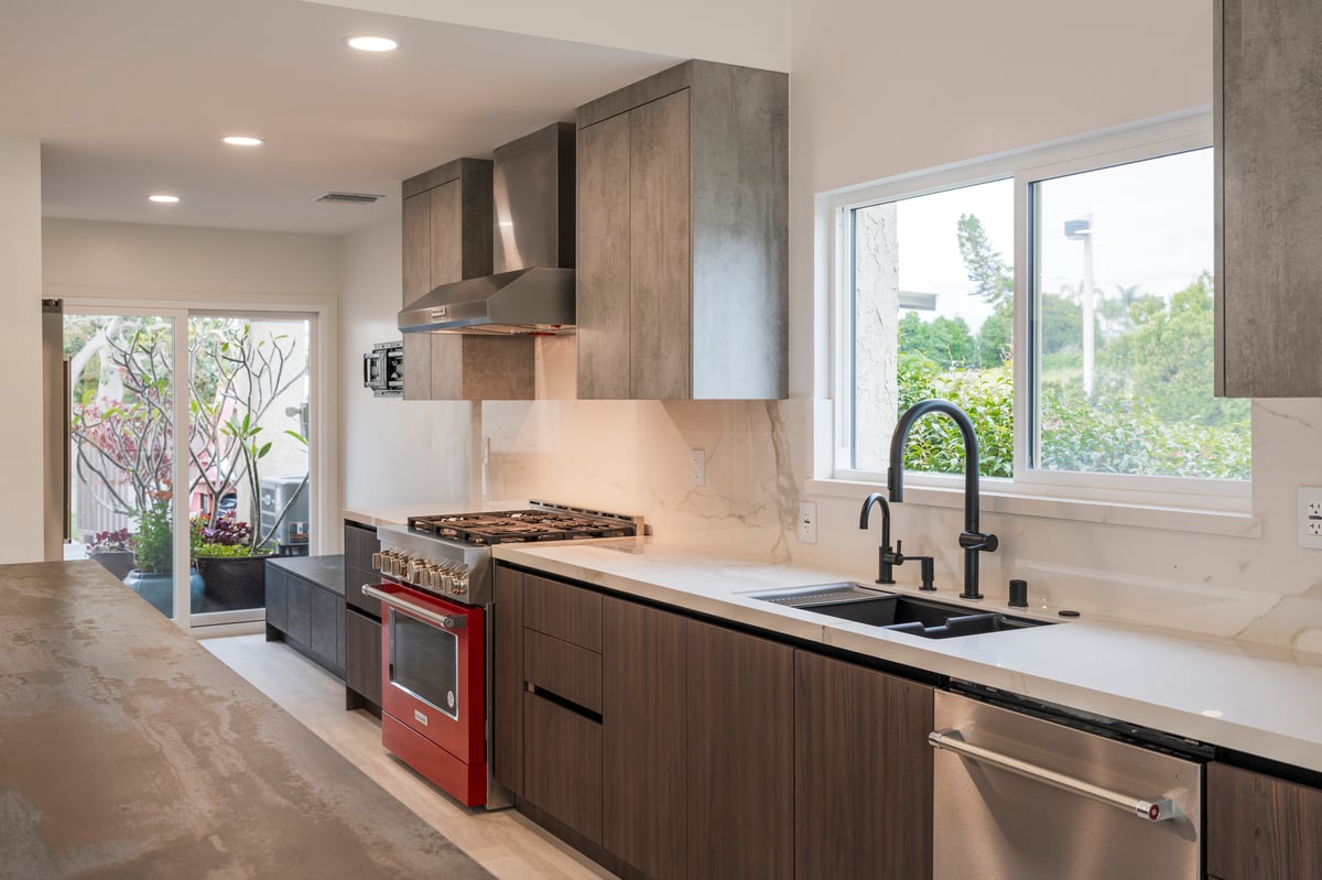 Wide view of modern kitchen with Dekton waterfall island and two-tone cabinetry
